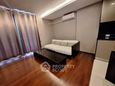 Modern living room with sleek design, featuring wooden floors, a comfortable sofa, and stylish lighting.