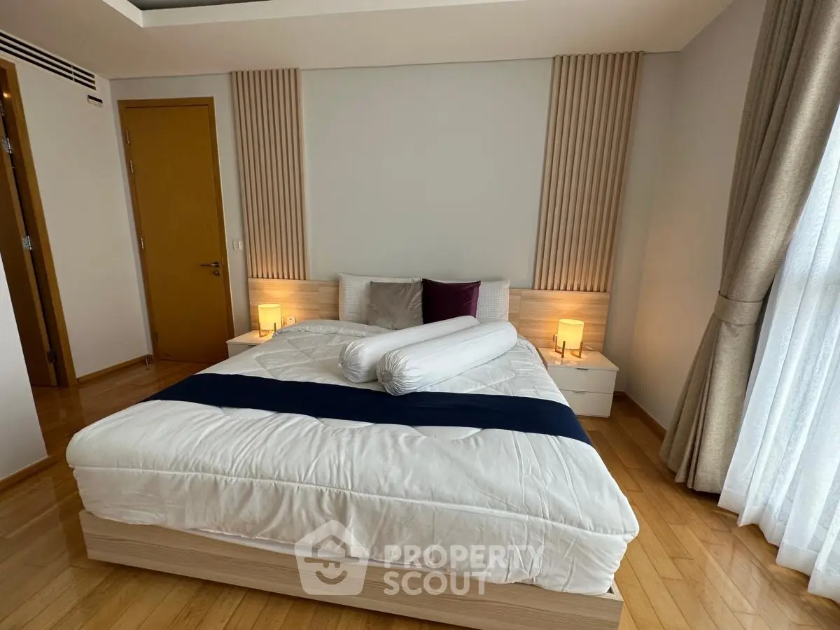 Luxurious bedroom with modern decor and cozy lighting, featuring a comfortable bed and elegant wooden flooring.