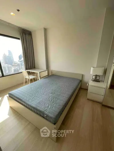 Modern bedroom with city view, featuring a minimalist design and ample natural light.
