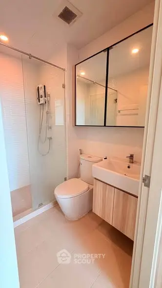 Modern bathroom with glass shower and sleek fixtures in a contemporary home.