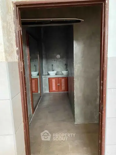 Modern bathroom with dual sinks and concrete walls, perfect for contemporary living.