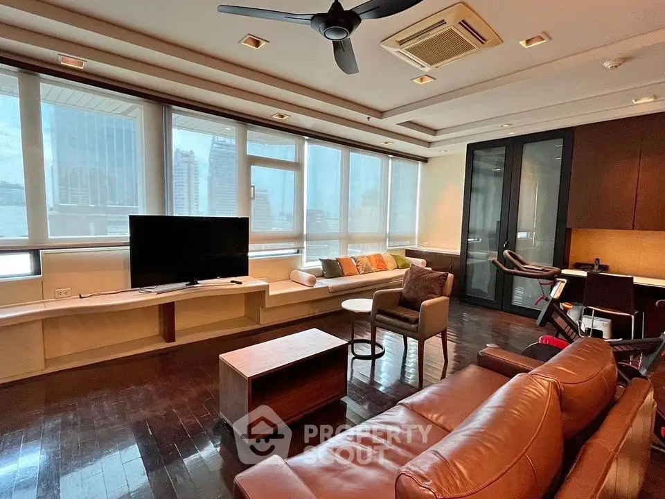 Spacious living room with city view, modern furniture, and ample natural light.