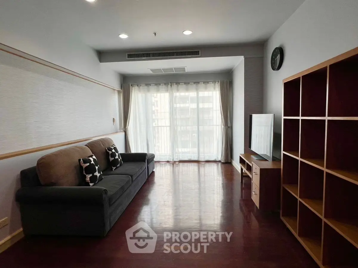 Spacious living room with modern sofa and large window offering natural light.