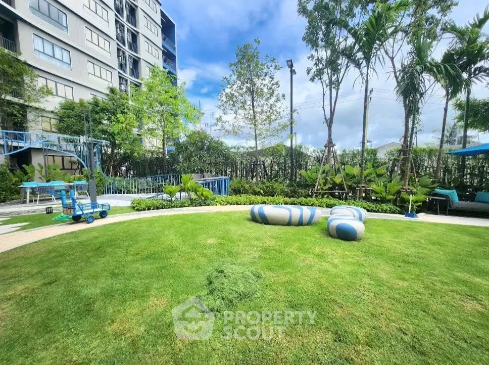 Lush garden area with modern seating in a residential complex, perfect for relaxation and outdoor activities.