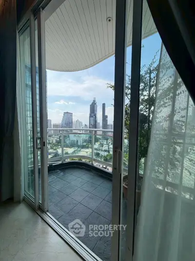 Stunning city view from modern apartment balcony with glass railing.
