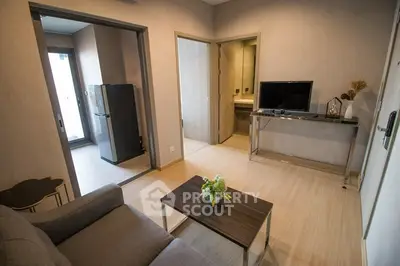 Modern living room with sleek furniture and open kitchen layout, perfect for urban living.
