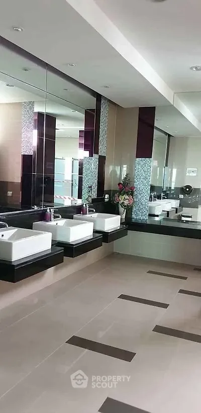 Spacious modern bathroom with sleek sinks and large mirrors, perfect for luxury living.