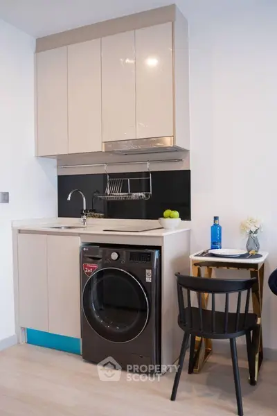 Modern compact kitchen with integrated washing machine and sleek cabinetry