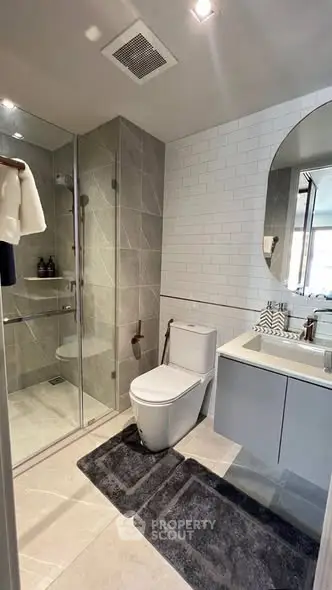 Modern bathroom with glass shower, sleek vanity, and contemporary fixtures.