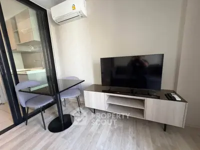 Modern living room with sleek TV stand and dining area in stylish apartment.