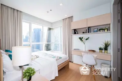 Bright modern bedroom with city view, featuring stylish decor and natural light.