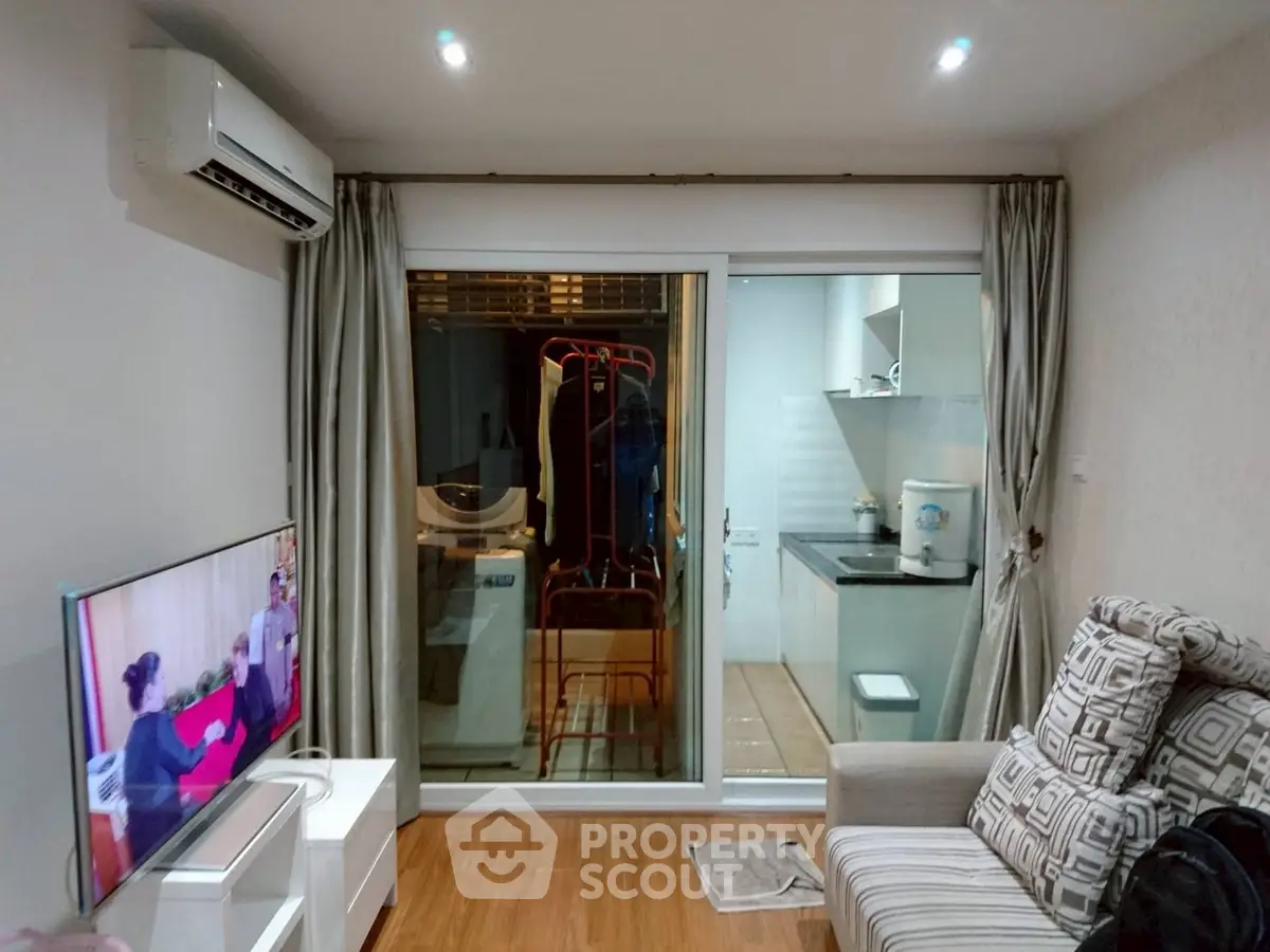 Cozy living room with modern decor and view into compact kitchen