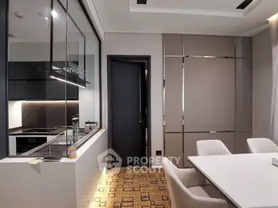 Modern kitchen with sleek design and dining area, featuring open layout and contemporary furniture.