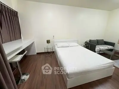 Modern minimalist bedroom with sleek furniture and wooden flooring