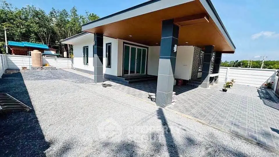 Modern single-story house with sleek design and spacious outdoor area.