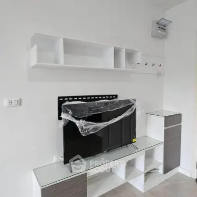 Modern living room with sleek TV stand and wall-mounted shelves in a minimalist design.
