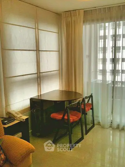 Cozy living room corner with modern furniture and large windows for natural light.