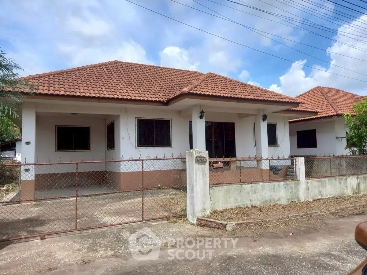 Charming single-story house with red-tiled roof and spacious front yard in a serene neighborhood.