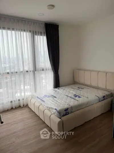 Modern bedroom with large window and stylish bed in high-rise apartment