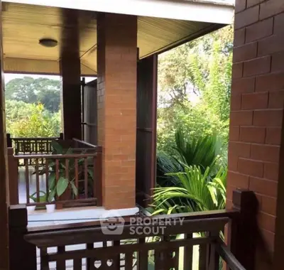 Charming balcony with lush greenery and wooden accents in serene setting.