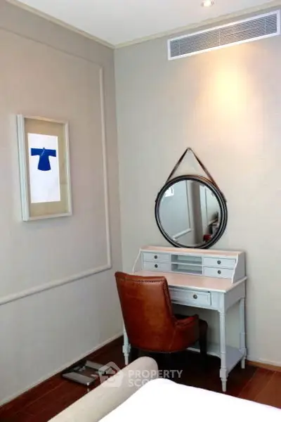 Chic bedroom corner with stylish vanity and leather chair, perfect for modern living.