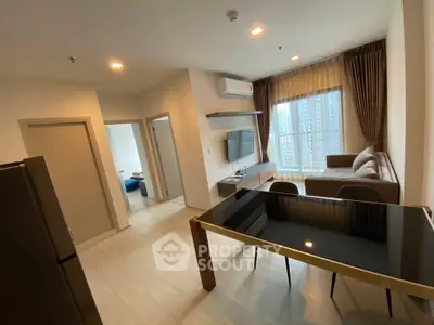 Modern living room with sleek furniture and large window offering city views