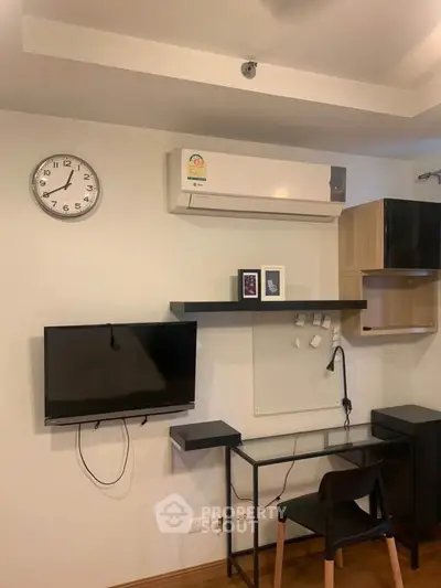 Modern study area with wall-mounted TV and air conditioning in a stylish apartment.