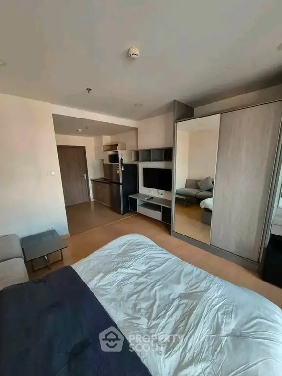 Modern studio apartment with open layout, featuring cozy living area and sleek kitchen design.