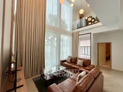 Luxurious high-ceiling living room with elegant leather sofas and modern decor
