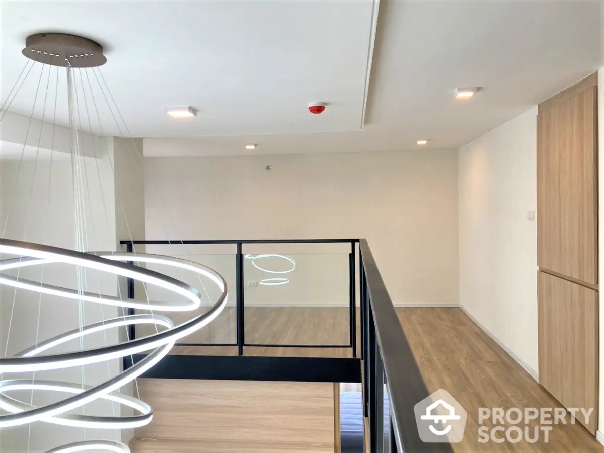 Modern duplex apartment interior with elegant spiral staircase leading to an upper level, showcasing sleek design and minimalist style.