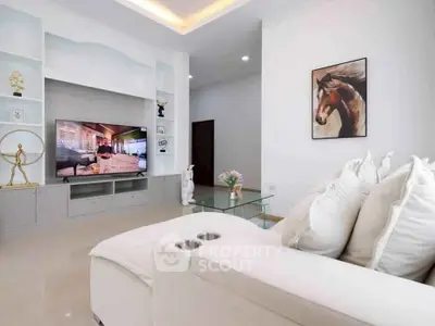 Modern living room with sleek decor and large TV, perfect for relaxation.