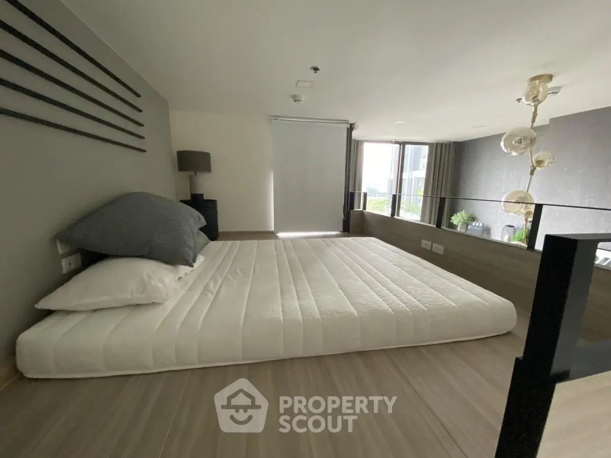 Modern minimalist bedroom with floor mattress and stylish decor in urban apartment.