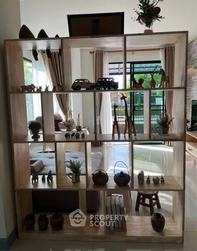 Stylish living room with decorative wooden shelving and large windows offering natural light.