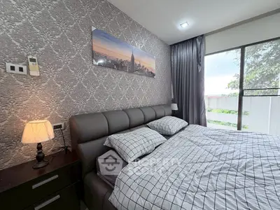 Modern bedroom with stylish decor and large window offering natural light.