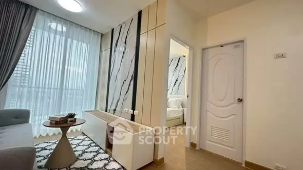 Modern living room with stylish decor and natural light, featuring a cozy seating area and elegant design.