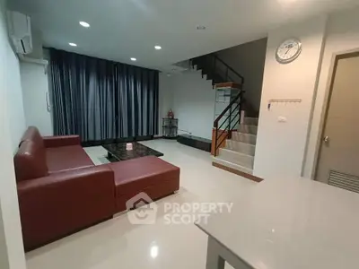 Modern living room with red sectional sofa and staircase in stylish home