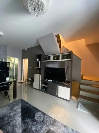 Modern living room with stylish staircase and entertainment unit