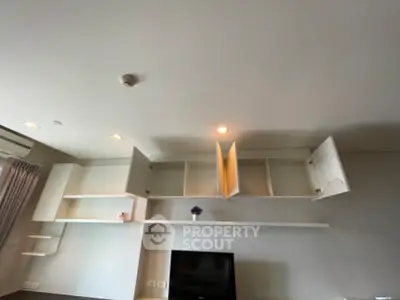 Modern living room with open shelving and TV setup, ideal for stylish urban living.