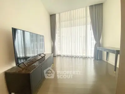 Modern living room with large TV and elegant curtains
