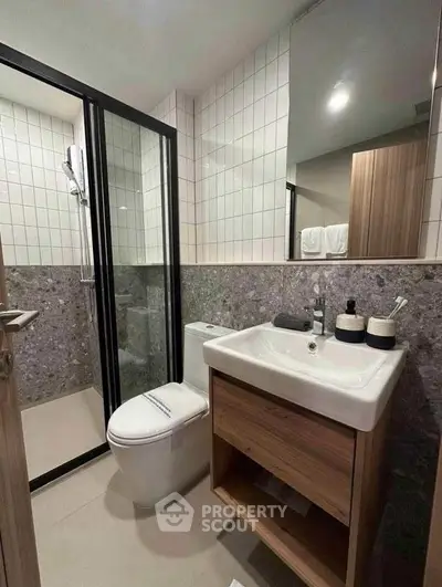 Modern bathroom with sleek design featuring a glass shower and stylish vanity.