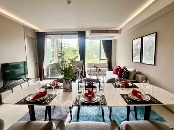 Elegant living room with dining area and large windows offering a lush garden view.