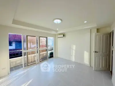 Bright and airy empty room with large windows and balcony access, perfect for customization.
