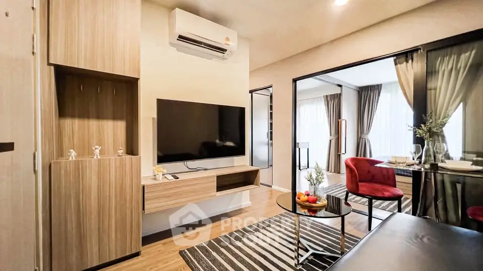 Modern living room with stylish decor and open layout, featuring a sleek TV setup and elegant dining area.