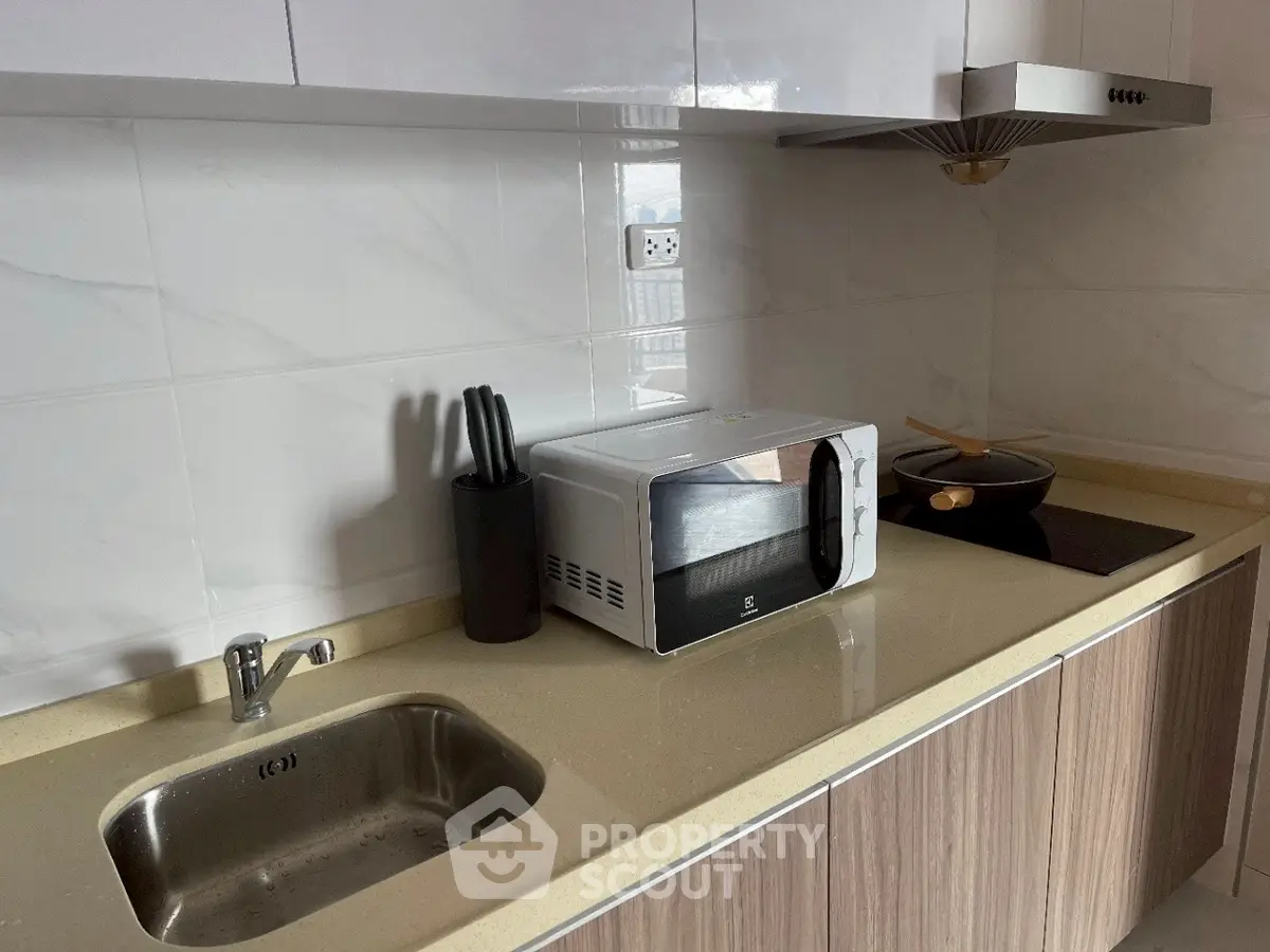 Modern kitchen with sleek countertops and built-in appliances, perfect for culinary enthusiasts.