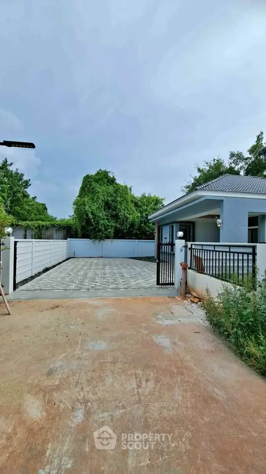 Charming single-story home with spacious driveway and lush greenery, perfect for serene living.