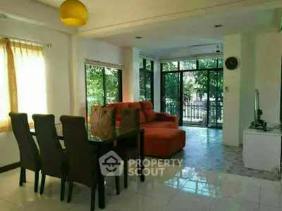 Spacious living room with large windows and modern dining area