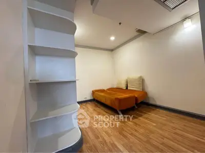Cozy living room with modern sofa and built-in shelves, perfect for relaxation.