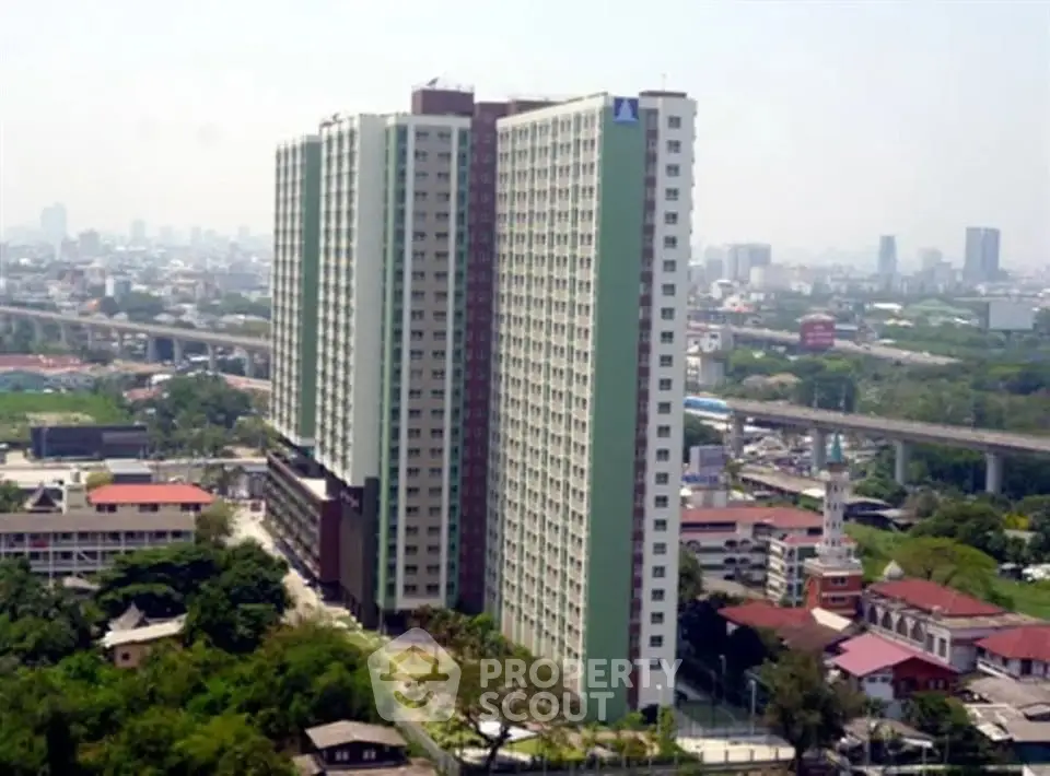 High-rise residential building with cityscape view and lush greenery surroundings.
