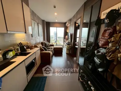 Modern open-layout living room with kitchen, cozy sofa, and city view balcony.