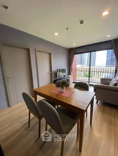 Modern living room with dining area and city view balcony in a stylish apartment.